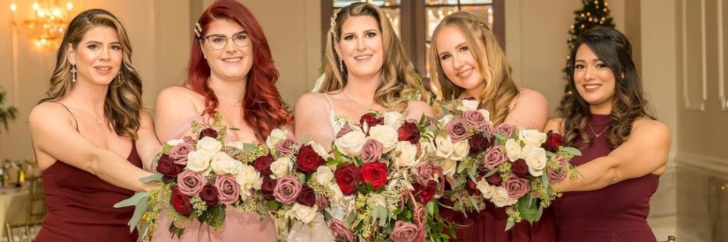 bride and bridesmaids holding lovely burgundy and cream bouquets